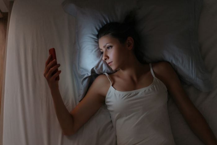 girl-cant-sleep-and-checking-her-mobile-phone