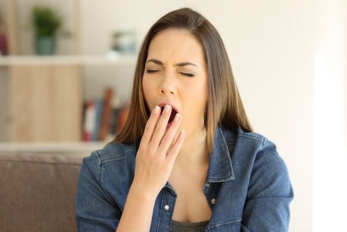 tired-woman-yawning-covering-mouth