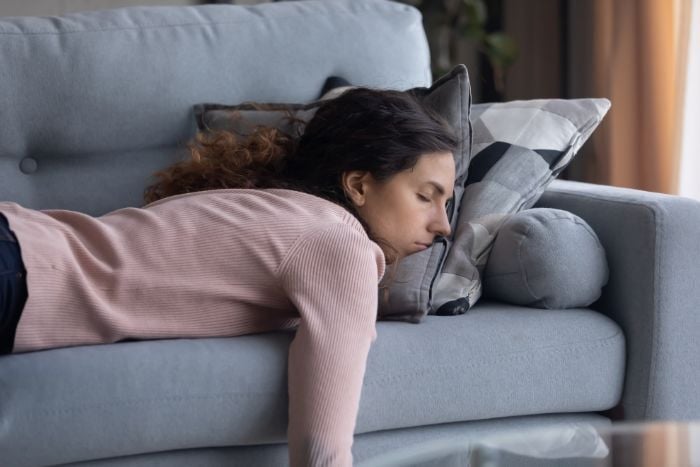 tired-young-woman-sleeping-on-couch-at-home