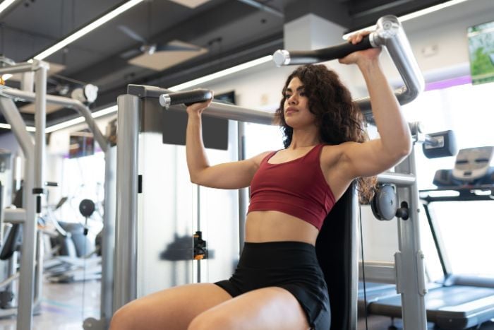 woman-exercising-with-a-shoulder-press-machine
