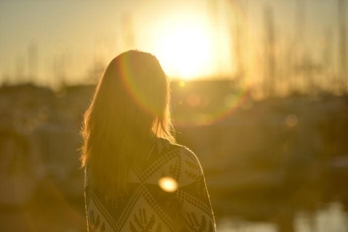 woman-standing-against-facing-sun