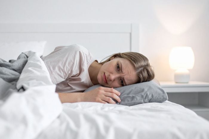 worried-woman-lying-awake-in-bed