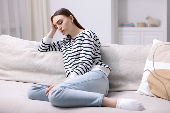 young-woman-feeling-fatigue-on-sofa-at-home