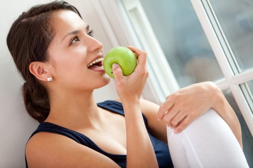 Healthy eating woman biting a green apple