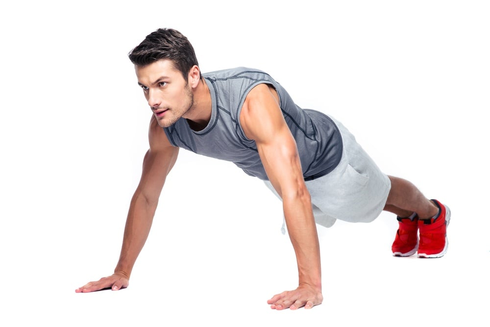 Sports man doing push ups isolated on a white background